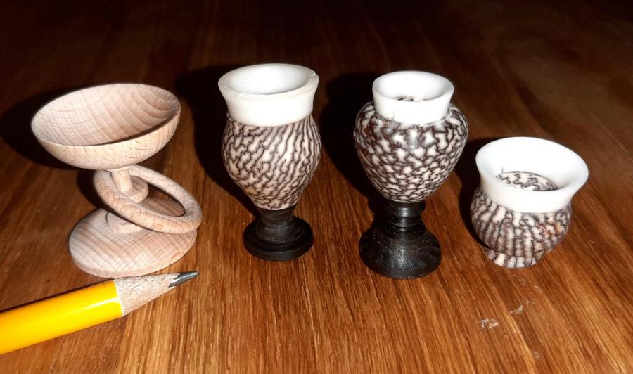 Eschenschale mit gefangenem Ring; die anderen drei Kelche sind aus Grenadillholz (schwarz), Betelnuss (gemustert) und Tagua-Nuss (weiß)